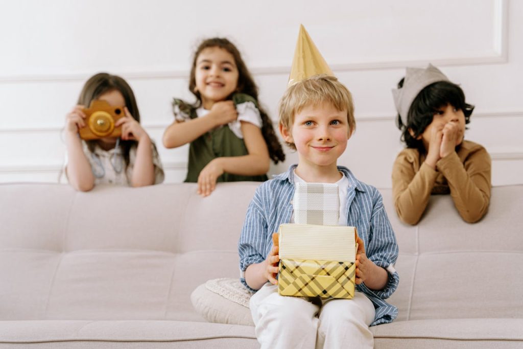 Joyful kids at a birthday party with presents and hats, capturing moments with a toy camera.